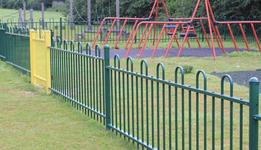 Green safety railings for the new play area with retro red swings